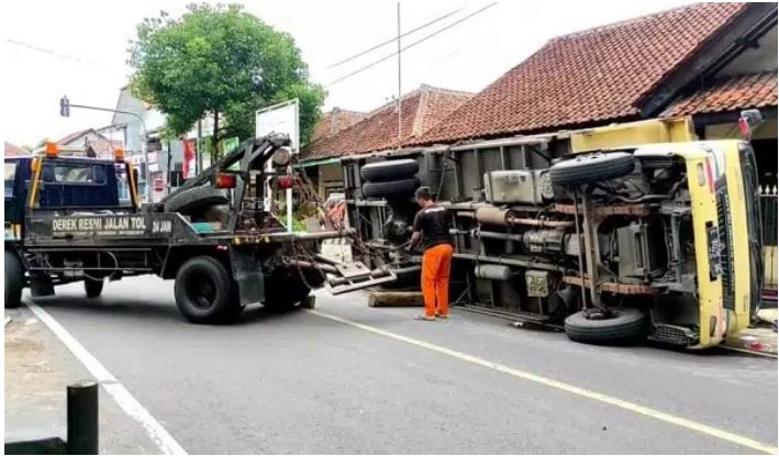 Diduga Rem Blong, Truk Asbes Terguling, Timpa Pagar Rumah Warga