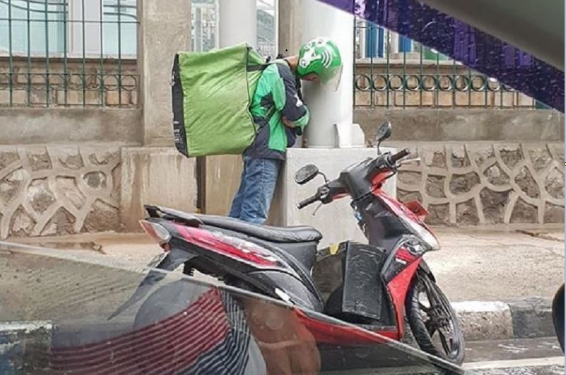 Viral, Driver Ojol Tidur Berdiri Sambil Gendong Pesanan, Banjir Simpati dari Warganet